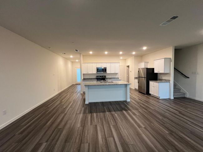 Kitchen with stainless steel appliances, dark wood-style flooring, white cabinetry, and recessed lighting | Image 12