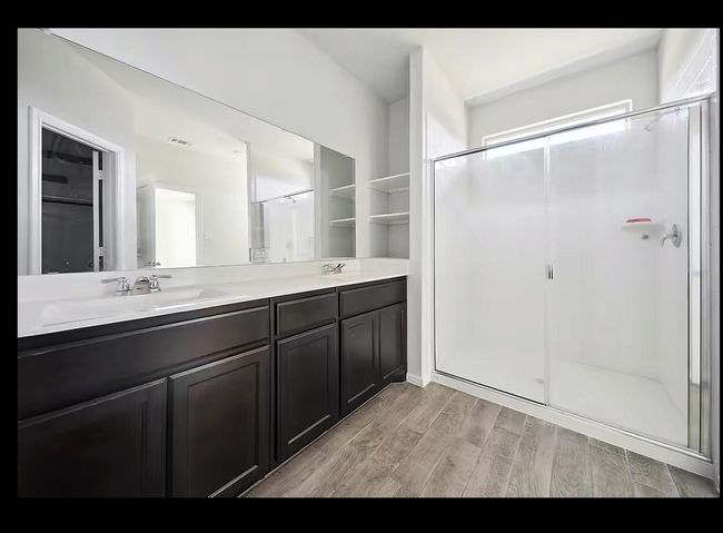 Full bathroom featuring double vanity, wood finished floors, and a stall shower | Image 9