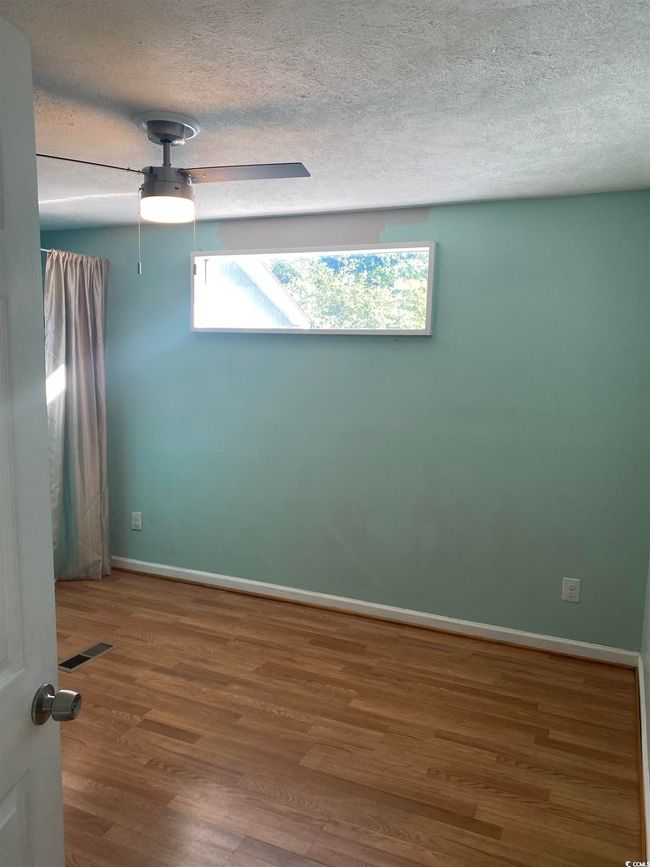 Spare room featuring a textured ceiling, wood finished floors, and ceiling fan | Image 24