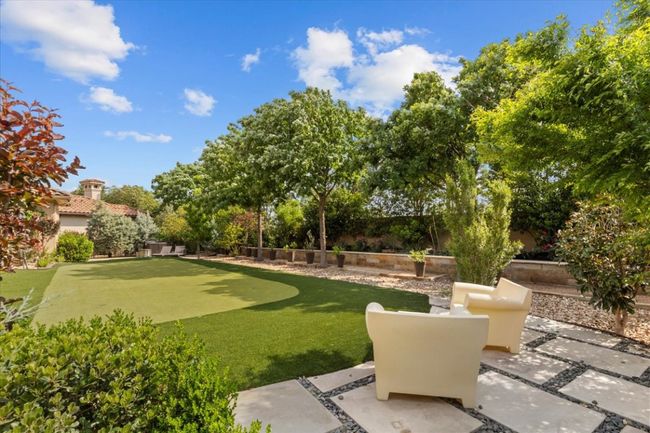 View of community featuring a fenced backyard and a patio area | Image 31