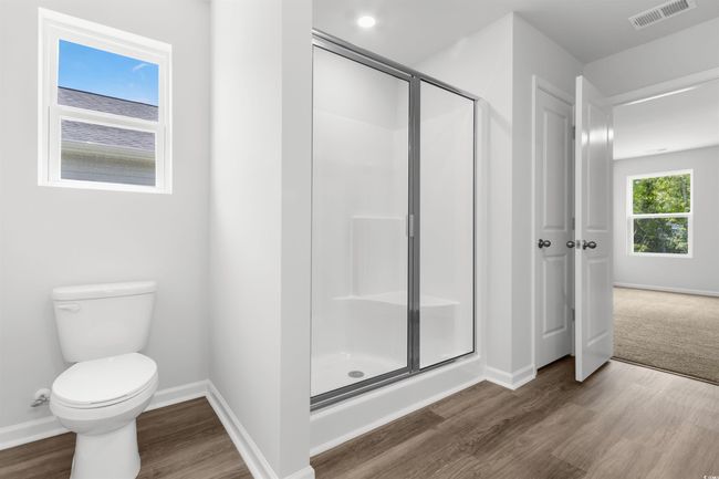 Bathroom with a shower with door, wood-type flooring, and toilet | Image 22