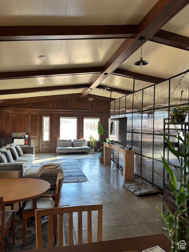 Living room featuring vaulted ceiling with beams and wooden walls | Image 57