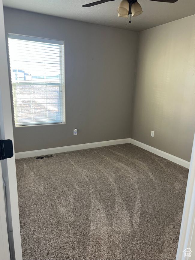 Carpeted spare room featuring a ceiling fan and baseboards | Image 46
