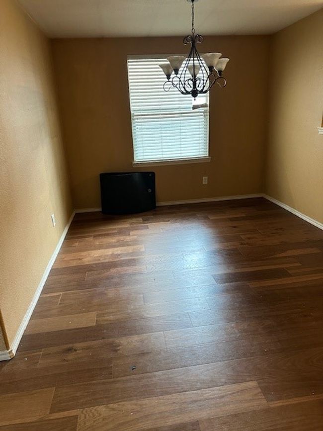 Empty room featuring a chandelier and wood finished floors | Image 26