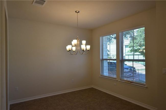 Empty room with a chandelier and baseboards | Image 4