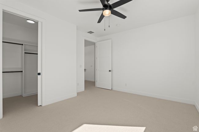 Unfurnished bedroom featuring light colored carpet, ceiling fan, and a spacious closet | Image 34
