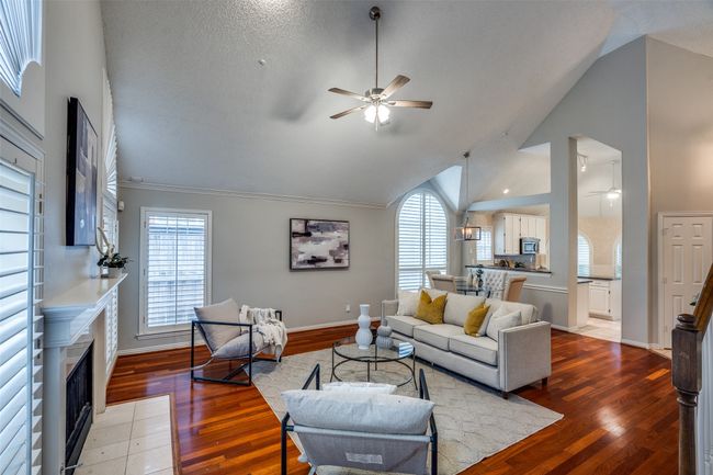 Living room with ceiling fan, plenty of natural light, wood finished floors, high vaulted ceiling, and crown molding | Image 4