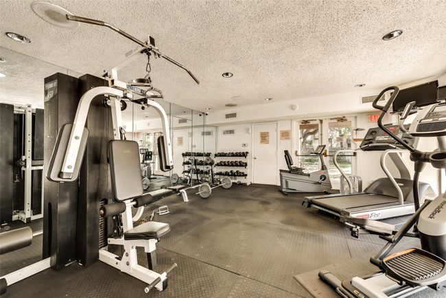 Exercise room with visible vents and a textured ceiling | Image 24