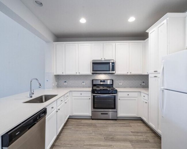 Kitchen with appliances with stainless steel finishes, light countertops, white cabinets, and recessed lighting | Image 5