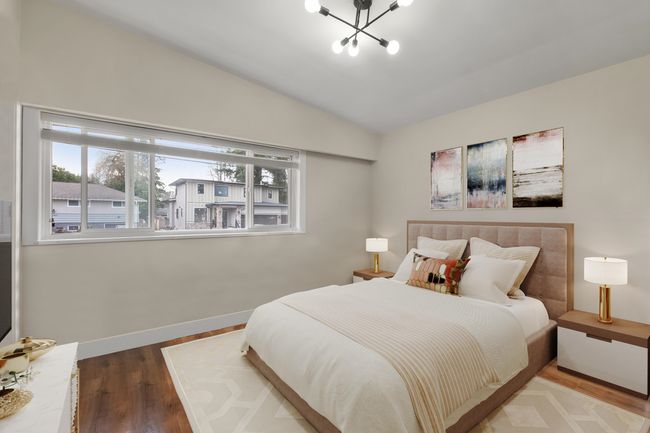 Bedroom featuring vaulted ceiling, baseboards, wood finished floors, and a notable chandelier | Image 8