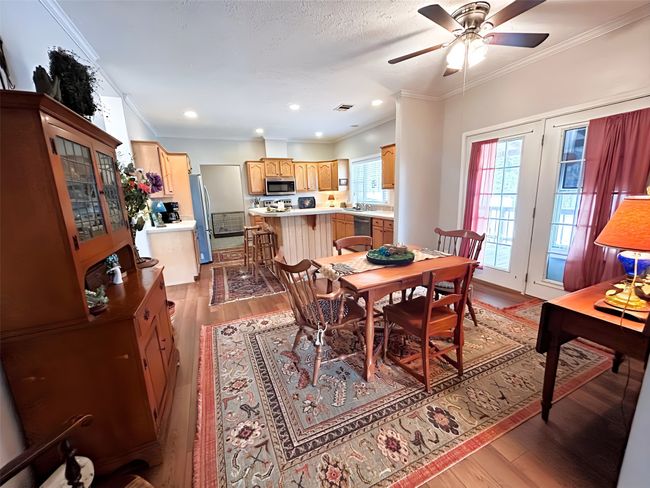 Dining space with visible vents, ornamental molding, light wood-style flooring, and a ceiling fan | Image 14
