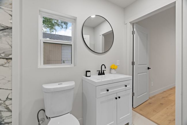 Bathroom featuring vanity, toilet, wood finished floors, and baseboards | Image 13