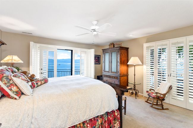 Primary bedroom with access to exterior, multiple windows, a water view | Image 21