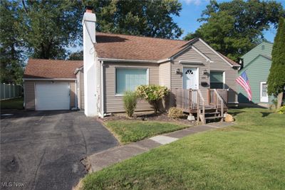 View of front of property featuring a front yard and a garage | Image 1