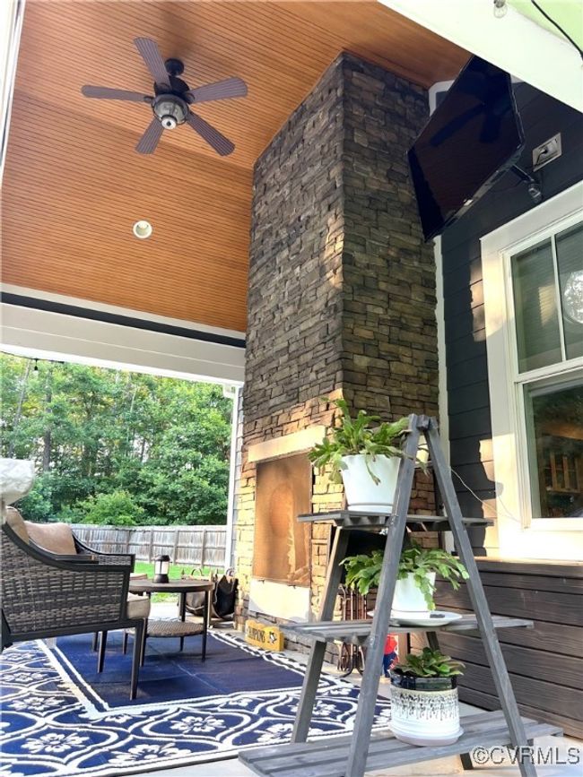 View of patio with a fireplace and a ceiling fan | Image 42