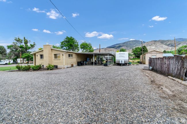 Rear view of house featuring brick siding, a mountain view, a chimney, and driveway | Image 27