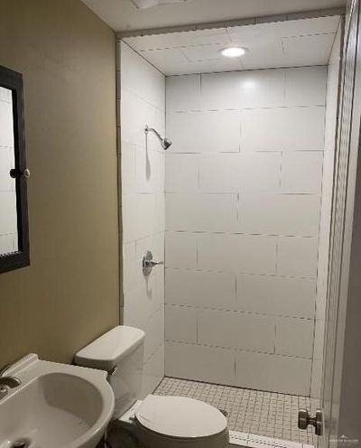 Bathroom featuring sink, tiled shower, and toilet | Image 3