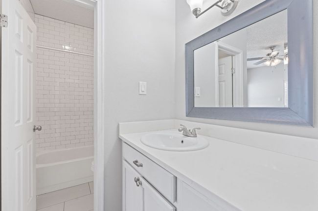 Bathroom featuring shower / bath combination, vanity, a ceiling fan, and tile patterned floors | Image 16