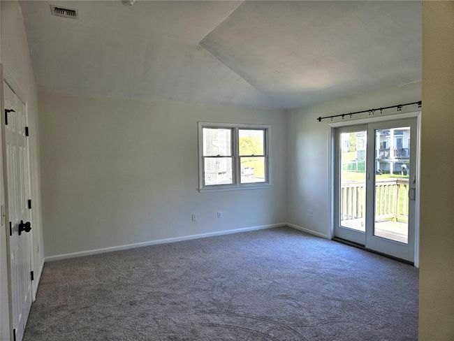 The Large, Elegant Primary Bedroom Offers Stunning Soaring Ceilings, Sliding Doors To A Deck, All New Neutral Carpeting, Ample Room For A Large Bedroom Set/Furniture, Walk In Closet & A Private Bathroom. | Image 9