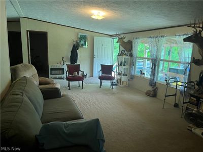 Carpeted living room with vaulted ceiling and a textured ceiling | Image 2