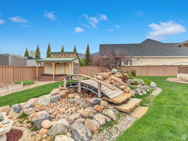 View of yard with a storage unit, an outbuilding, a hot tub, and a fenced backyard | Image 46