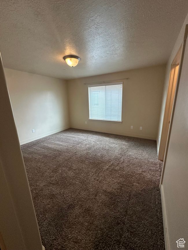 Spare room featuring carpet flooring, a textured ceiling, and baseboards | Image 18