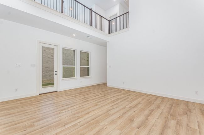 Unfurnished room with a towering ceiling and light wood-style flooring | Image 13