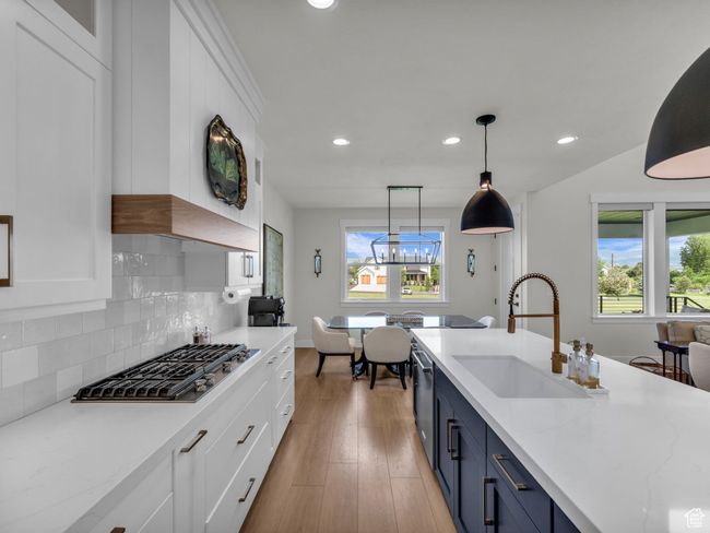 Kitchen featuring blue cabinetry, stainless steel appliances, a sink, recessed lighting, and white cabinetry | Image 14