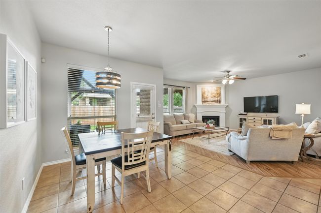 Dining space with ceiling fan, light tile patterned flooring, plenty of natural light, and a fireplace | Image 26