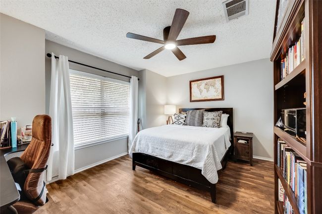 Bedroom with wood finished floors, baseboards, a textured ceiling, and ceiling fan | Image 22