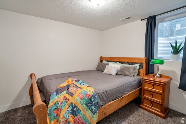Carpeted bedroom featuring a textured ceiling, visible vents, and baseboards | Image 12