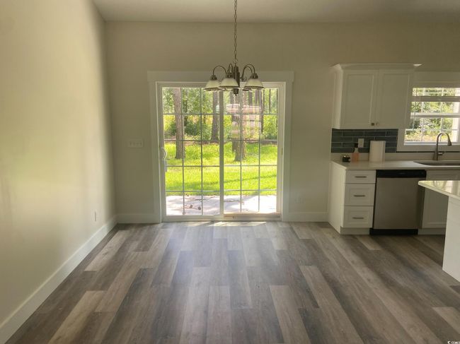 Unfurnished dining area with a chandelier, plenty of natural light, and wood finished floors | Image 10