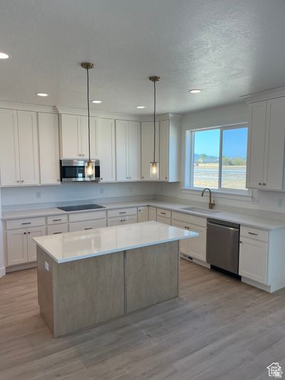 Kitchen with pendant lighting, stainless steel appliances, white cabinetry, and a center island | Image 3