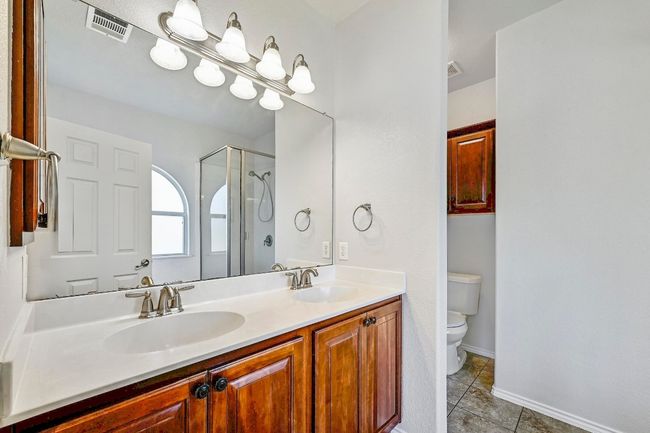 Bathroom with tile patterned flooring, double vanity, and a shower with shower door | Image 19