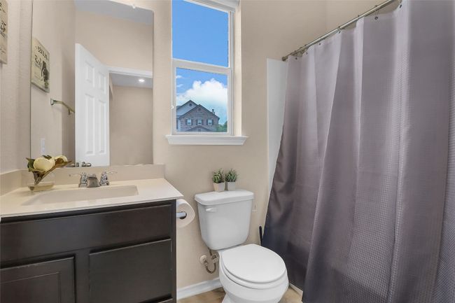 Bathroom with toilet, vanity, and a shower with shower curtain | Image 15