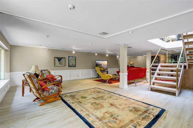 Recreation room with light wood-style flooring, visible vents, rail lighting, wainscoting, and a skylight | Image 25