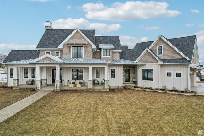 View of front of property featuring a standing seam roof, a shingled roof, a porch, and board and batten siding | Image 56