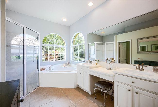 Primary luxury bathroom with dual sinks, vanity, soaking jet bath and separate walk-in shower. | Image 20