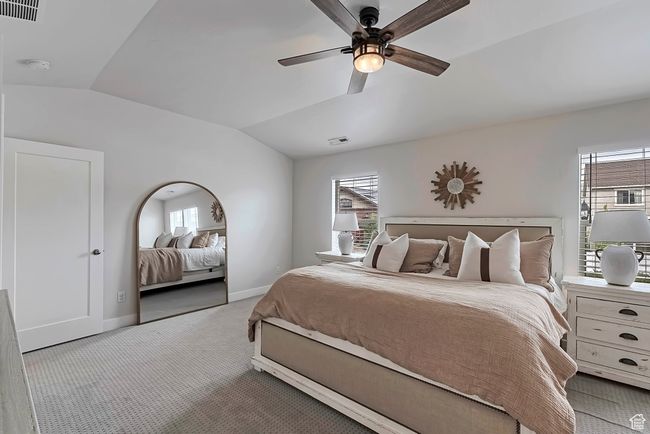 Carpeted bedroom with lofted ceiling, baseboards, multiple windows, and a ceiling fan | Image 14
