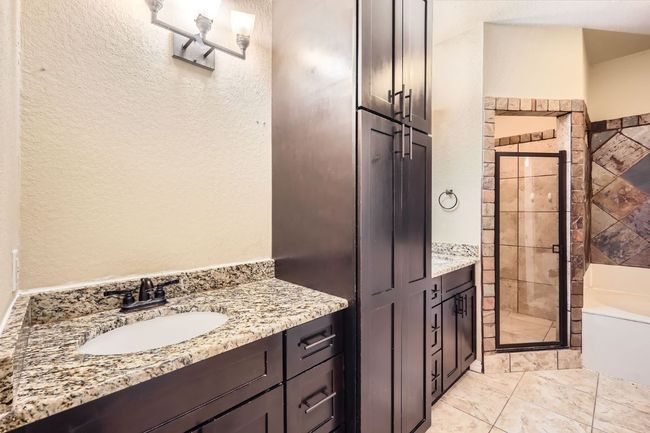 Full bath with a stall shower, vanity, a garden tub, and a textured wall | Image 10