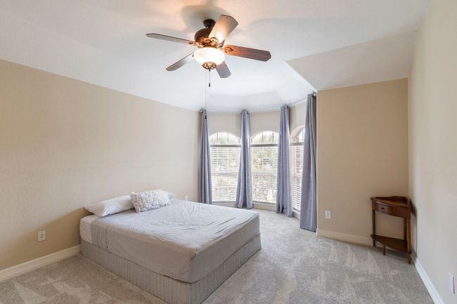 Bedroom with light carpet, a ceiling fan, and baseboards | Image 33