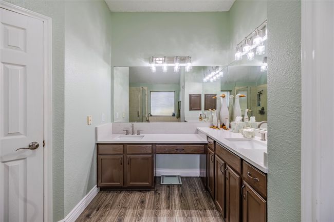 Bathroom with a stall shower, double vanity, wood finished floors, and baseboards | Image 23