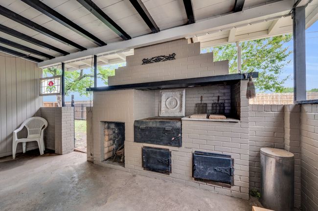 Living area featuring unfinished concrete floors, a fireplace, and healthy amount of natural light | Image 23