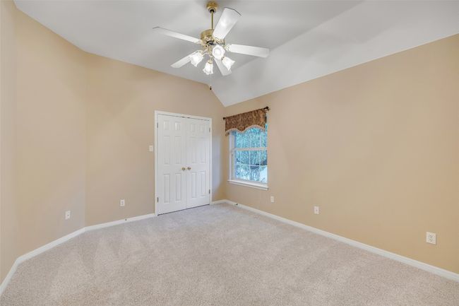 Empty room with light carpet, lofted ceiling, and a ceiling fan | Image 28