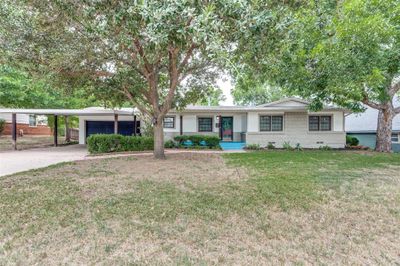 Ranch-style home with a front lawn and a garage | Image 1