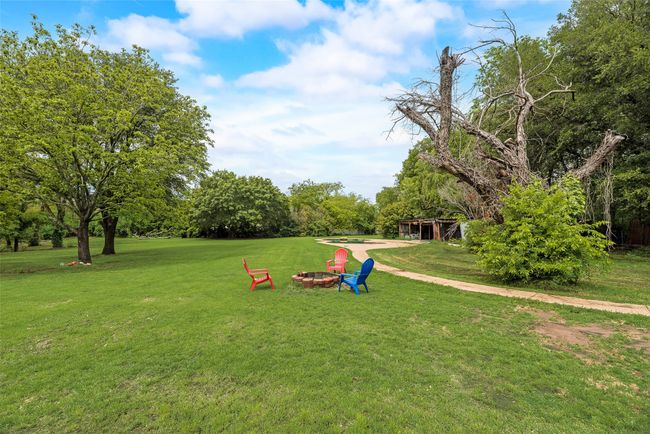 Surrounding community with an outdoor fire pit and a yard | Image 6