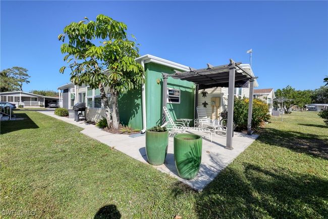 Rear view of house with a pergola, a patio area, and a yard | Image 28