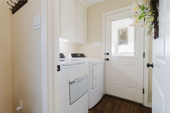 Washroom featuring cabinets, separate washer and dryer, and dark wood-type flooring | Image 7