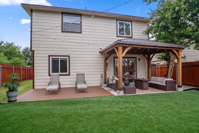 Rear view of property with an outdoor living space, a fenced backyard, a gazebo, and a patio | Image 10