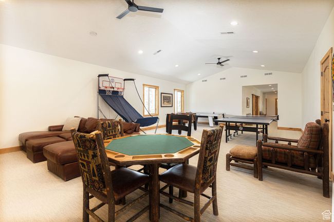 Dining space featuring a ceiling fan, vaulted ceiling, light colored carpet, and visible vents | Image 34